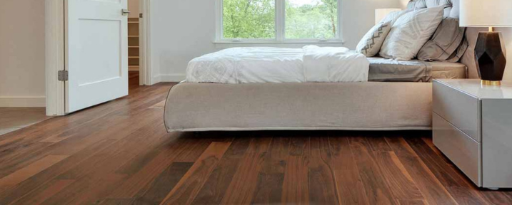 Dark Hardwood flooring in a clean white bedroom